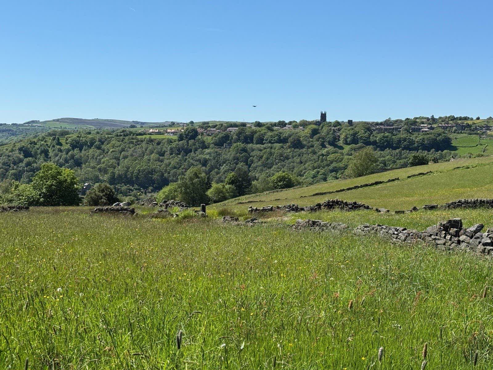 The Calder Valley with a church tower across the far hillside, seen from above Hebden Bridge